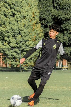 Joven jugando Fútbol con uniforme deportivo personalizado